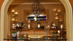 A dining area with a glass table, decorative vases, and a chandelier. - Villa Casato Residenza Boutique (Campos do Jordão)