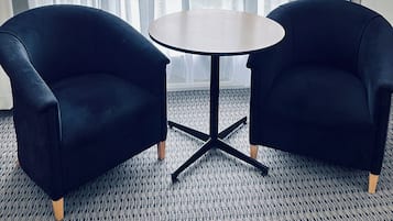 Escritorio, cortinas blackout y tabla de planchar con plancha
