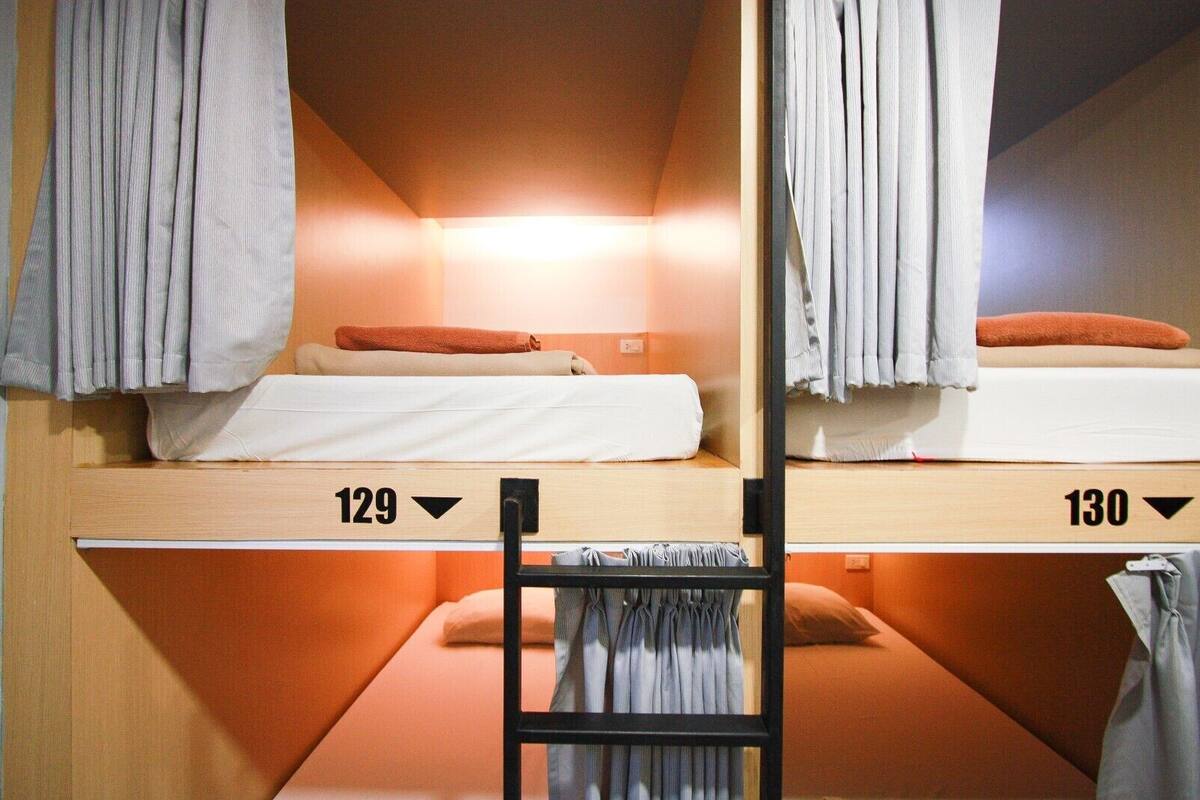 Two bunk beds labeled 129 and 130, with curtains and pillows.