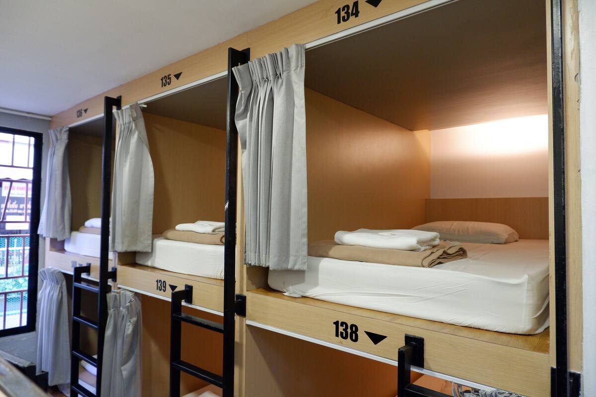 A row of bunk beds in a dormitory room, each with a number above it.