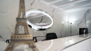 A modern interior with a marble wall, a large mirror, and a decorative Eiffel Tower model.