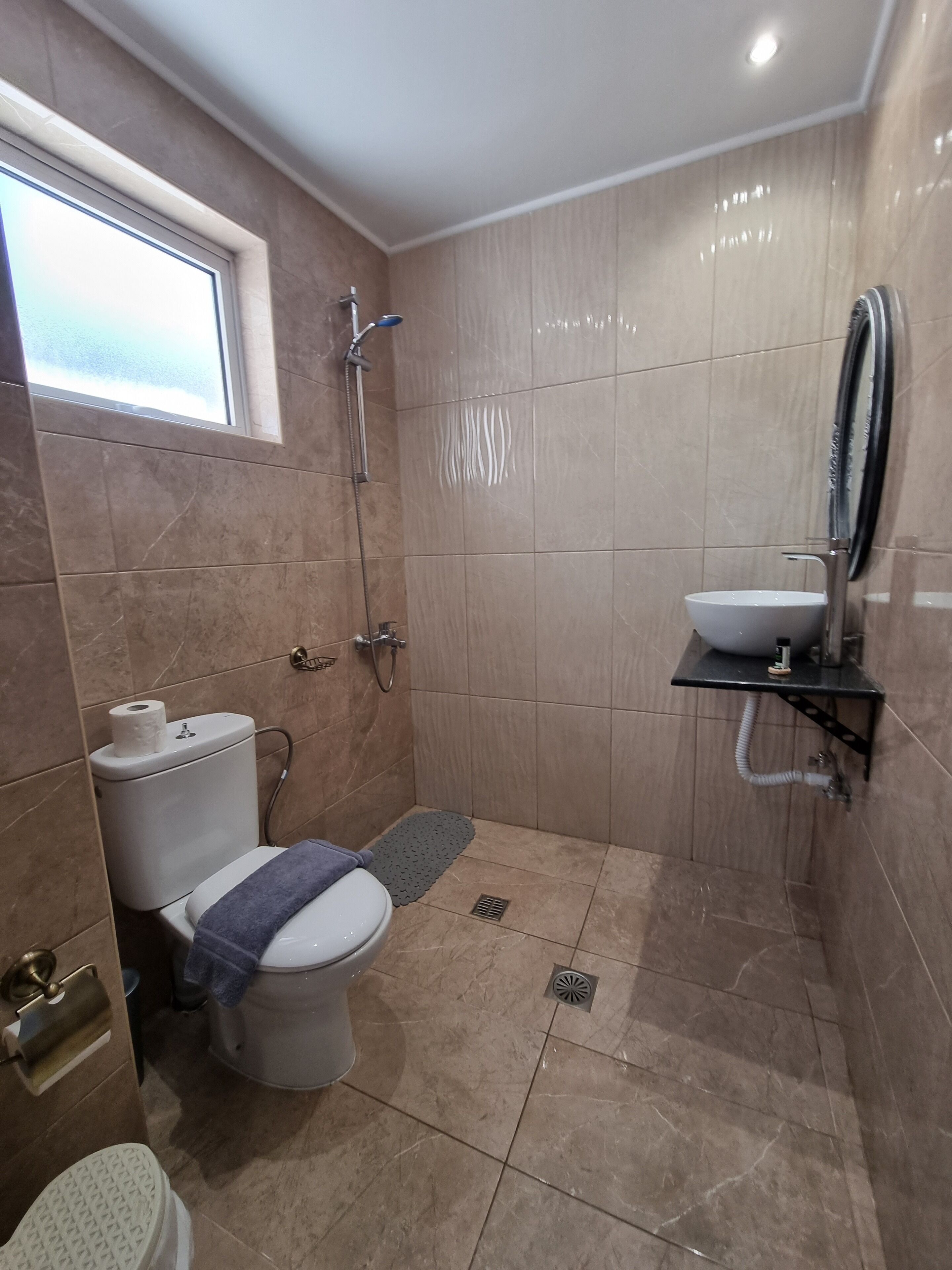 A bathroom with a toilet, shower, and sink.