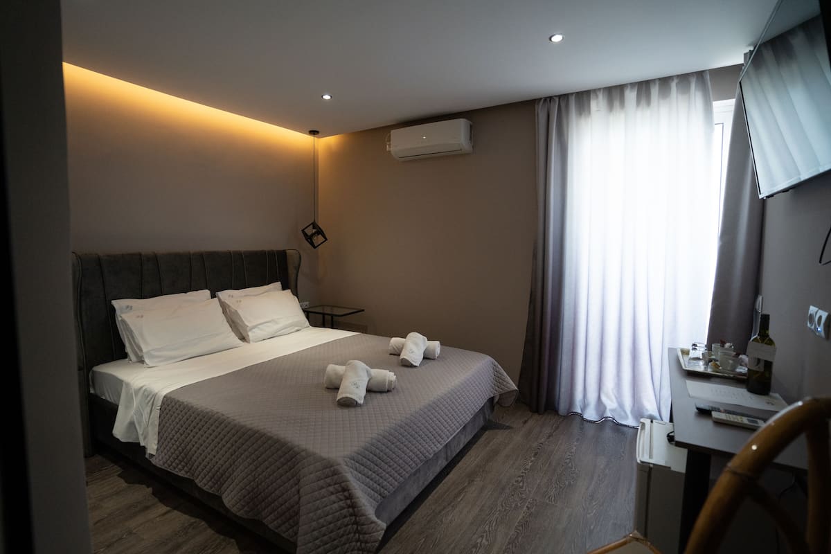 A hotel room with a bed, a desk, and a chair.