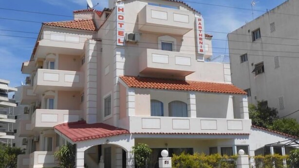 A multi-story hotel with a red-tiled roof, balconies, and a sign indicating it is a hotel.