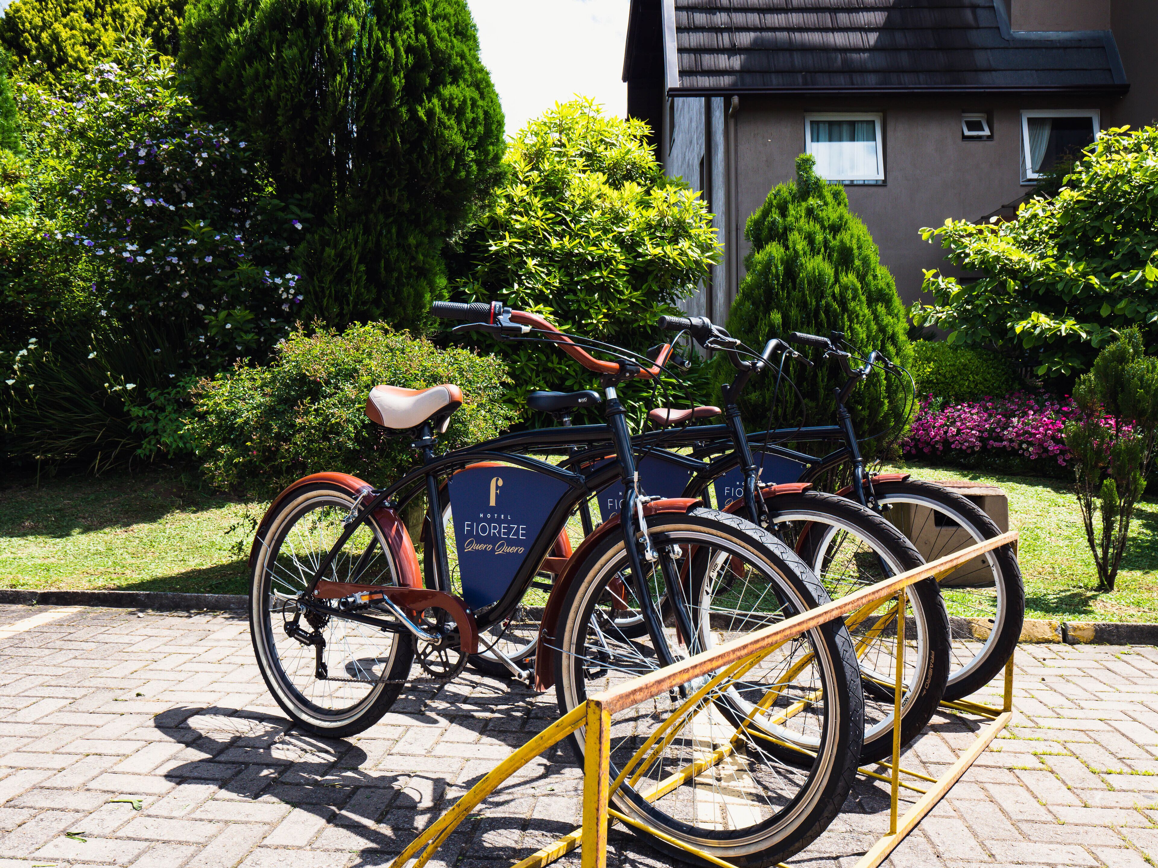 A bicycle rental station with bicycles parked in front of a building with a sign that reads "Hotel Fioreze."