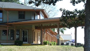 A two-story building with a covered porch and a sign indicating 'KEEP RIGHT'. - Woodlawn Hills Motel (Henderson)