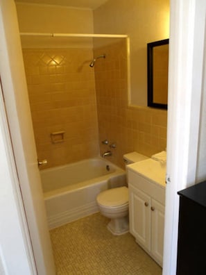 A bathroom with a bathtub, toilet, and sink.