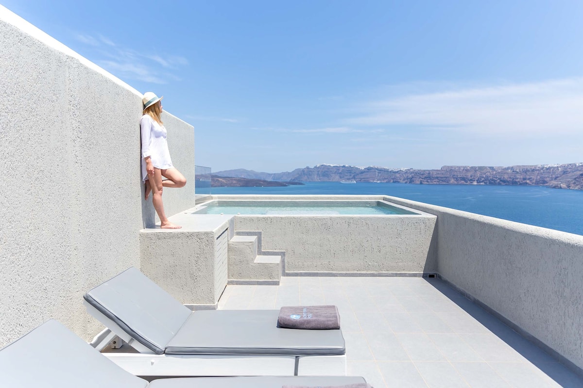 A rooftop pool with a clear view of the sea and distant mountains.