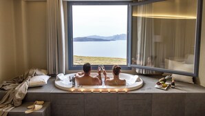Una pareja en una bañera con vistas a un lago.