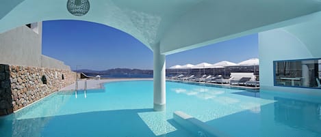 Una piscina al aire libre de temporada, sombrillas