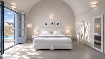 Quarto moderno com uma cama grande, duas mesas de cabeceira, vista para uma piscina e uma parede de pedra.