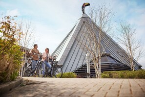 Un edificio moderno con un techo triangular distintivo y una escultura de pájaro en la parte superior.