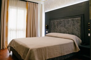 A hotel room with a bed, curtains, and a wall-mounted light fixture. - Leonardo (Durres)