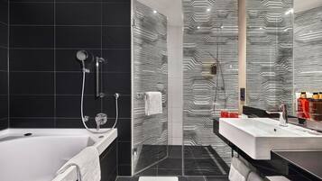 Ein modernes Badezimmer mit Badewanne, einer Duschkabine aus Glas und einem Waschtisch mit Waschbecken.
