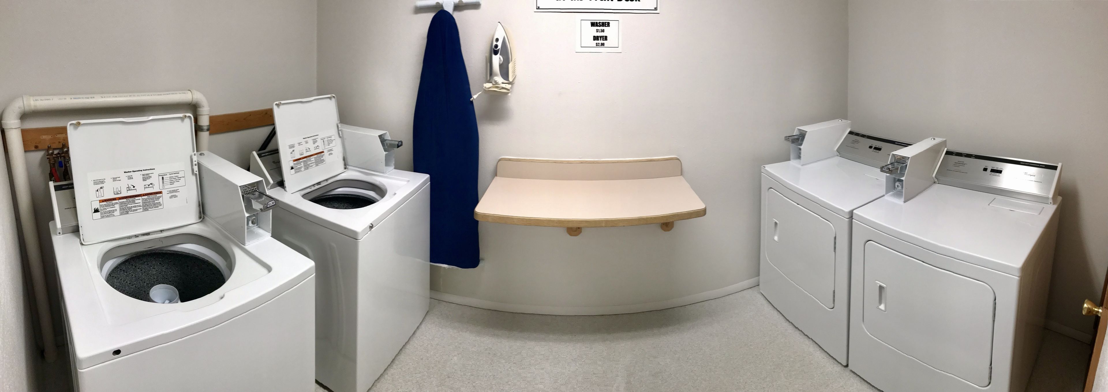 A compact laundry room with a washing machine, dryer, and ironing station.