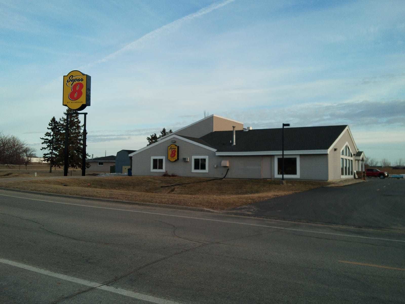 A Super 8 motel with a single-story building, a garage, and a large sign.