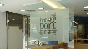 Una recepción de hotel con un panel de vidrio que muestra el nombre del hotel.