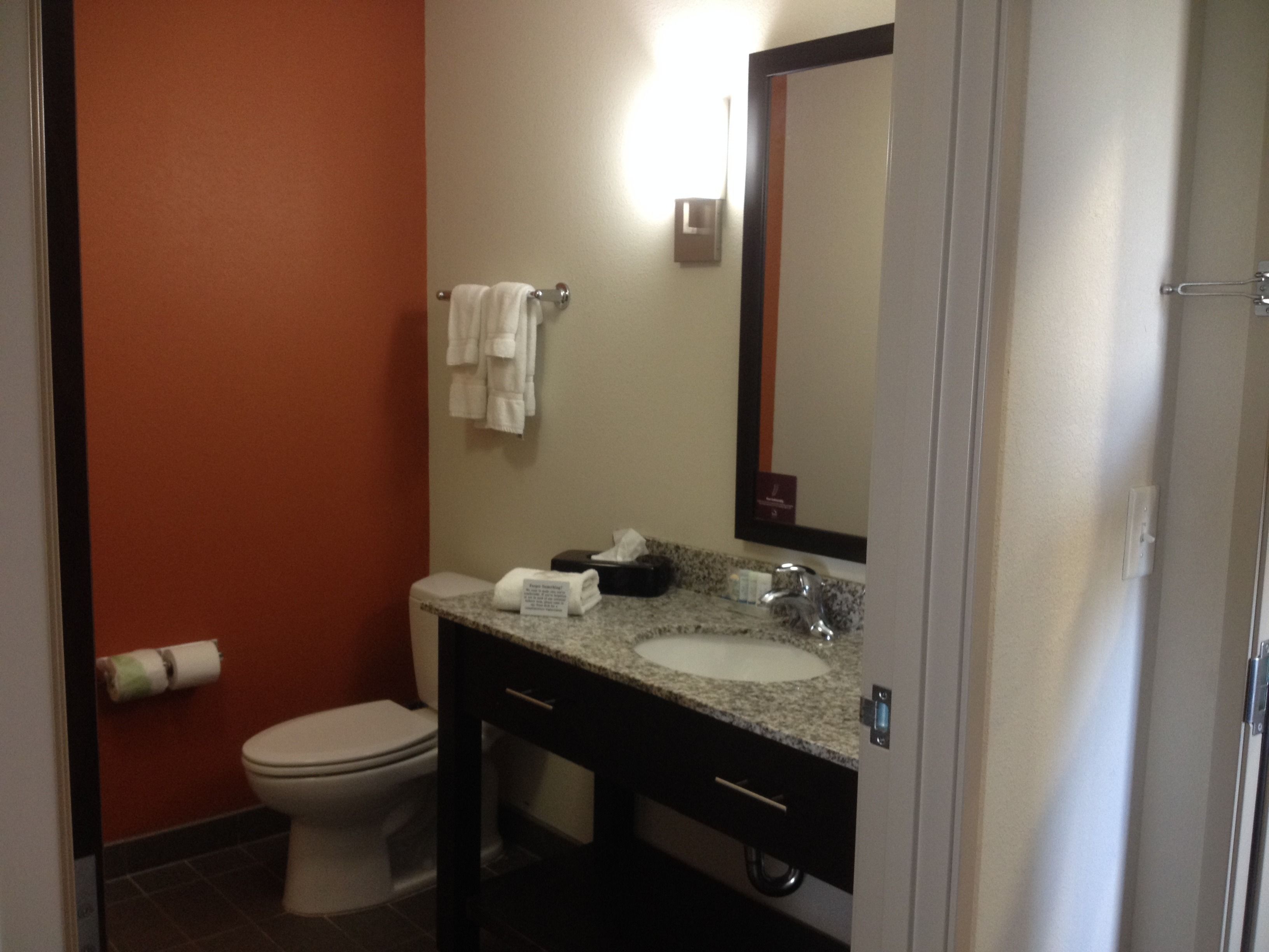 A compact bathroom with a toilet, sink, and mirror.