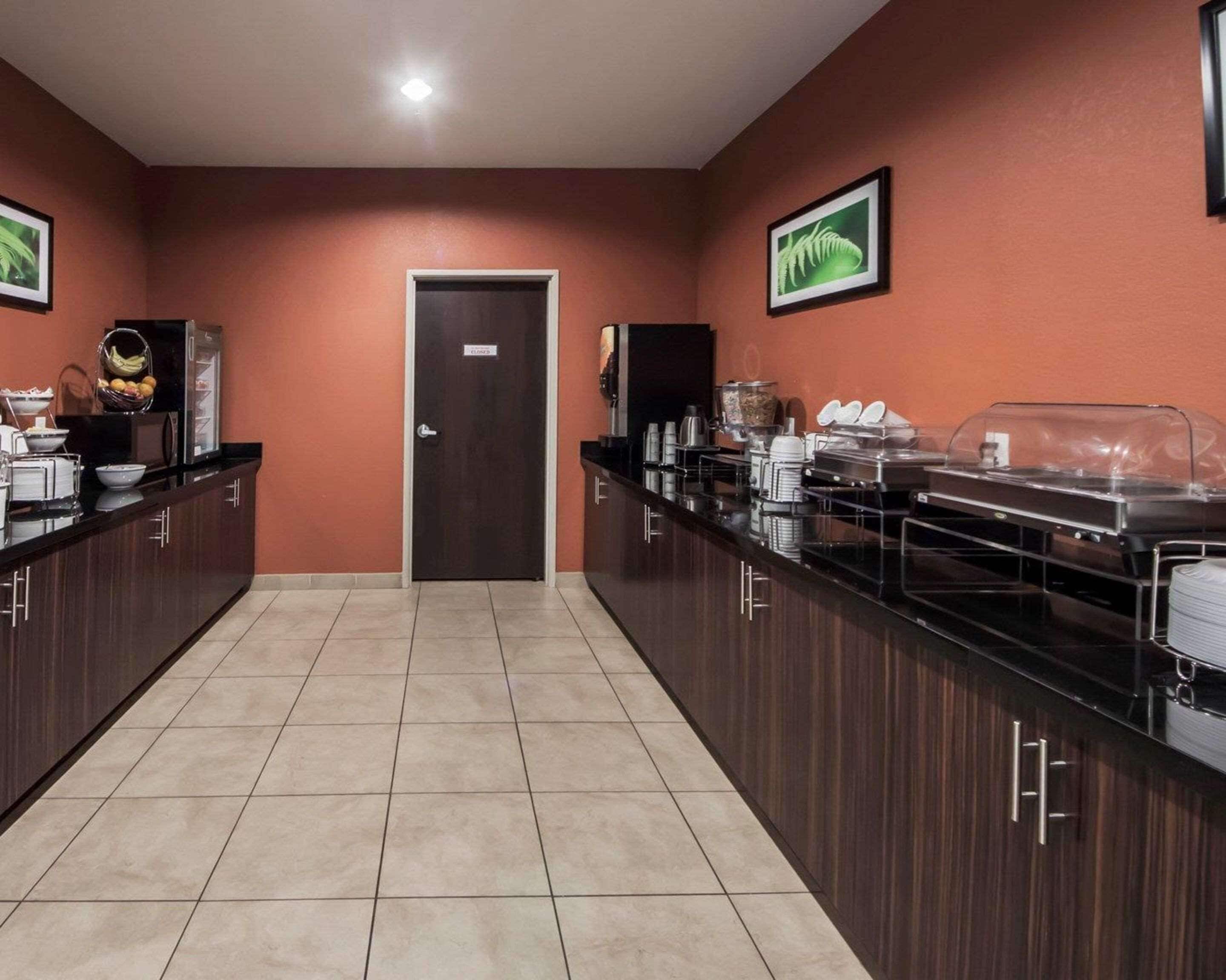 Une cuisine d’hôtel équipée d’un buffet, comprenant un réfrigérateur, une machine à café et divers produits alimentaires.
