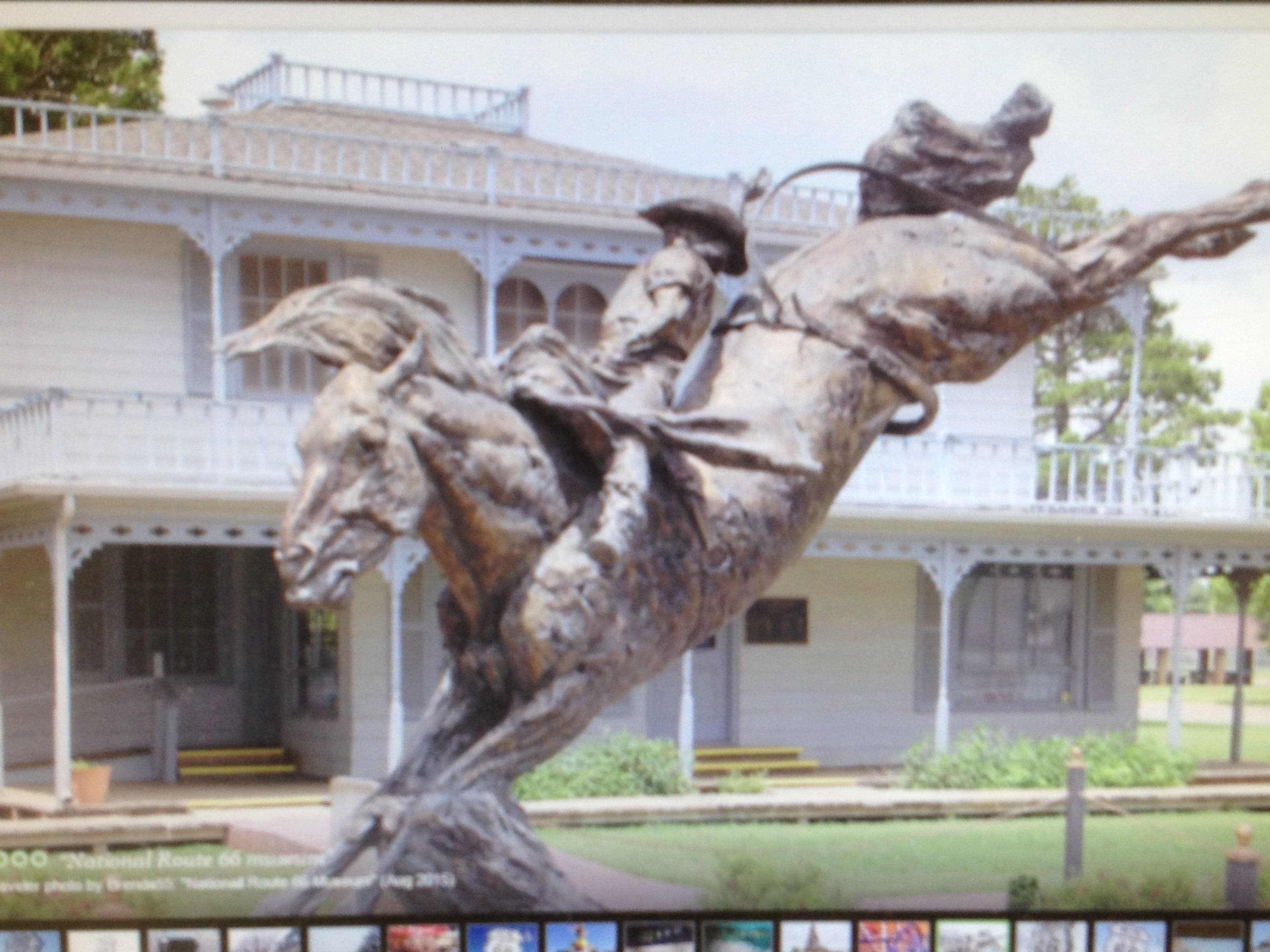 Un bâtiment doté d’un balcon et orné d’une statue représentant un cavalier sur un cheval.
