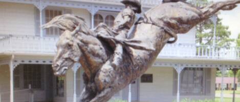 A building with a balcony and a statue of a horse and rider.