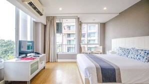 A hotel room with a large bed, a desk with a computer, and a window with curtains. - Cinnamon Hotel Bangkok (Bangkok)