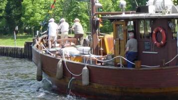 Un bote de madera con gente a bordo, amarrado en un muelle.