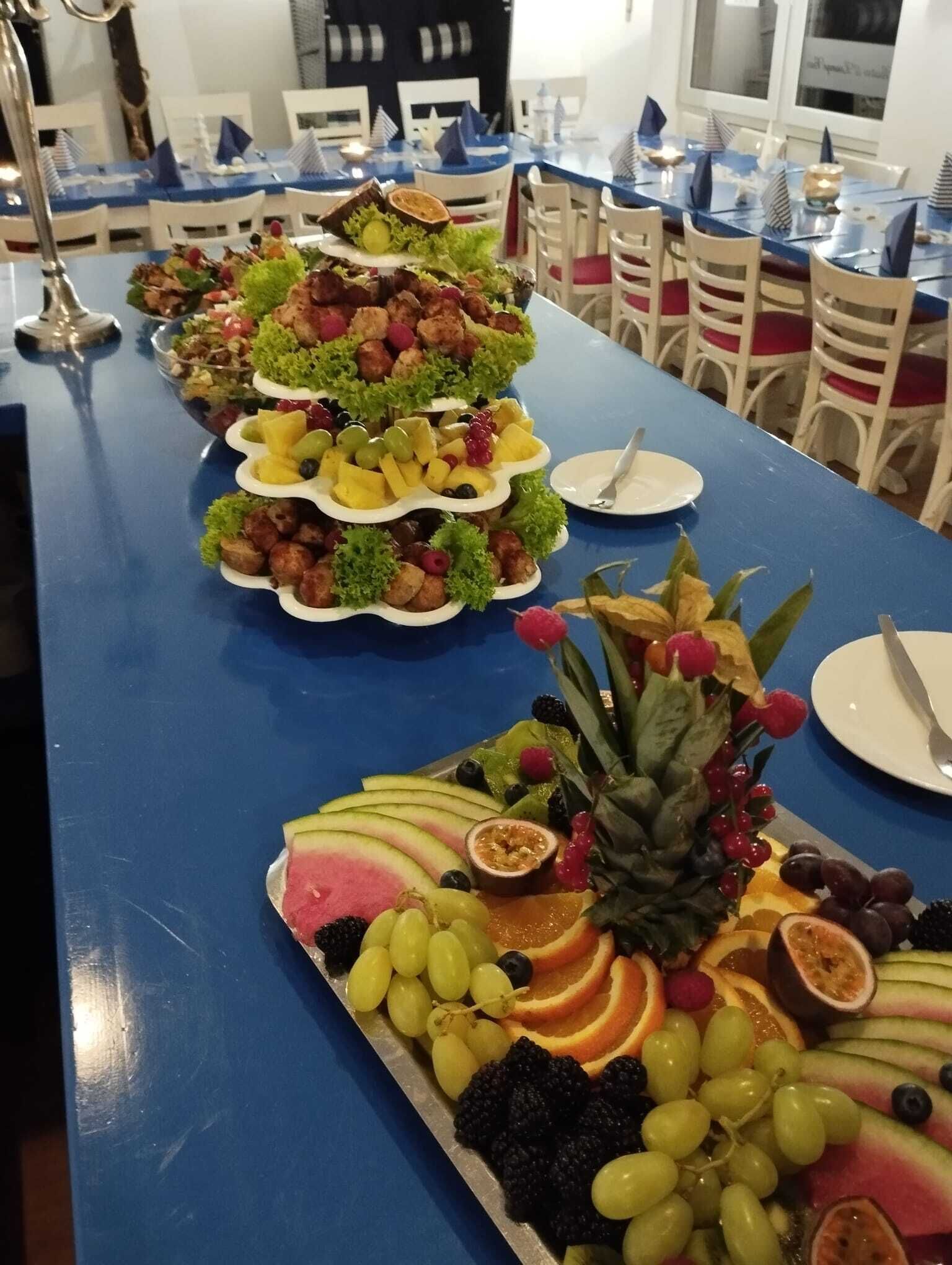 A buffet table with various fruit and vegetable platters.