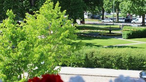 A well-maintained garden with a paved walkway, neatly trimmed hedges, and a variety of flowering plants. - Hotel Läckö (Lidköping)