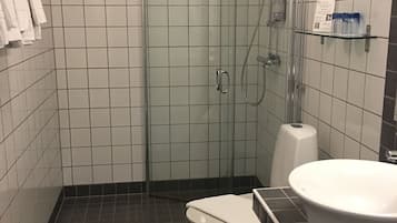 A bathroom with a glass-enclosed shower, a toilet, and a sink.