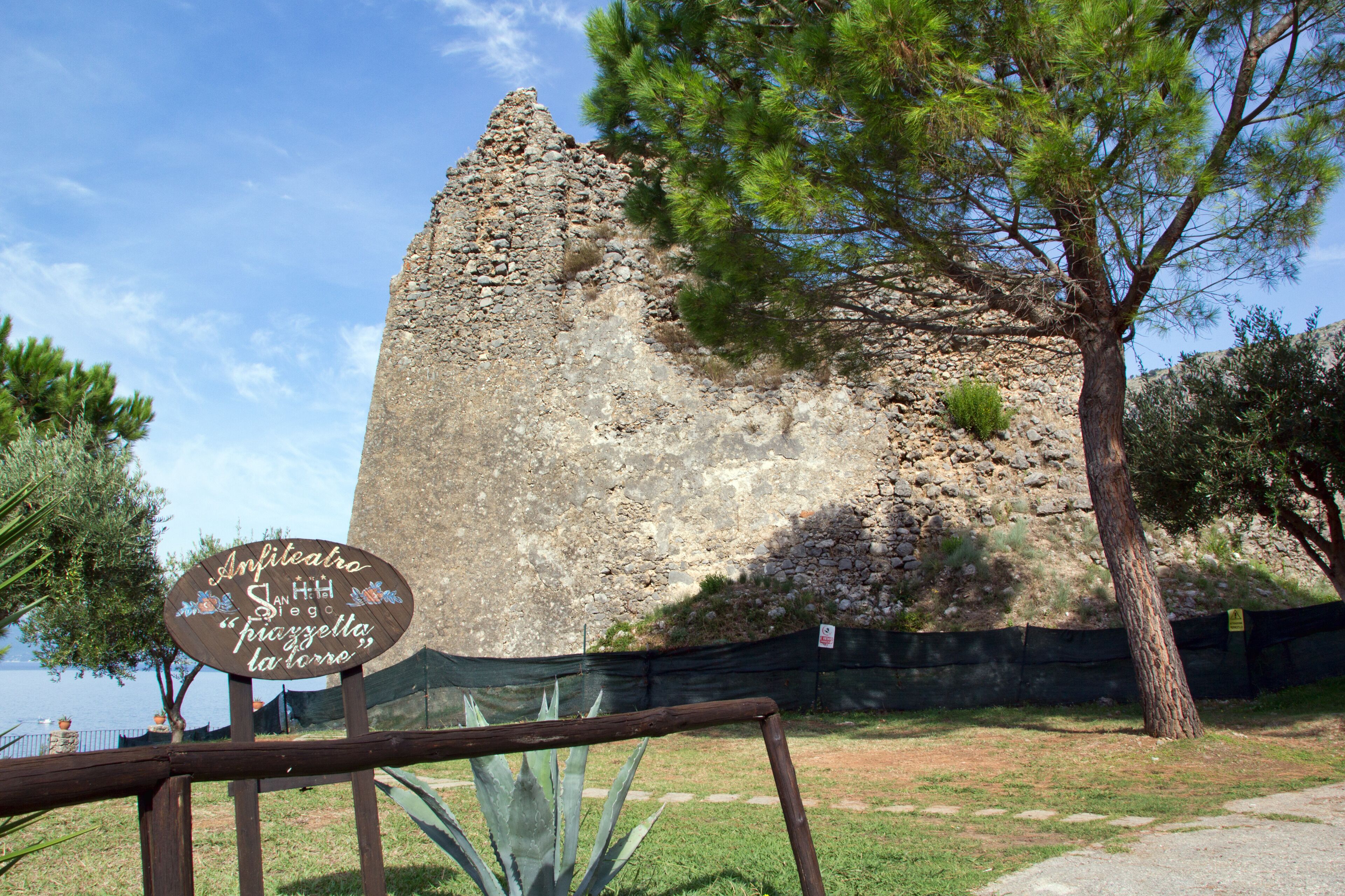 A stone ruin with a sign in front.