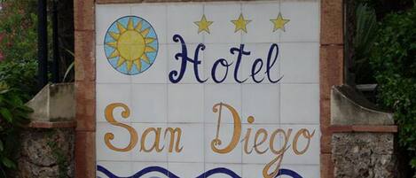 A sign for a hotel named "Hotel San Diego" with a sun and wave design.