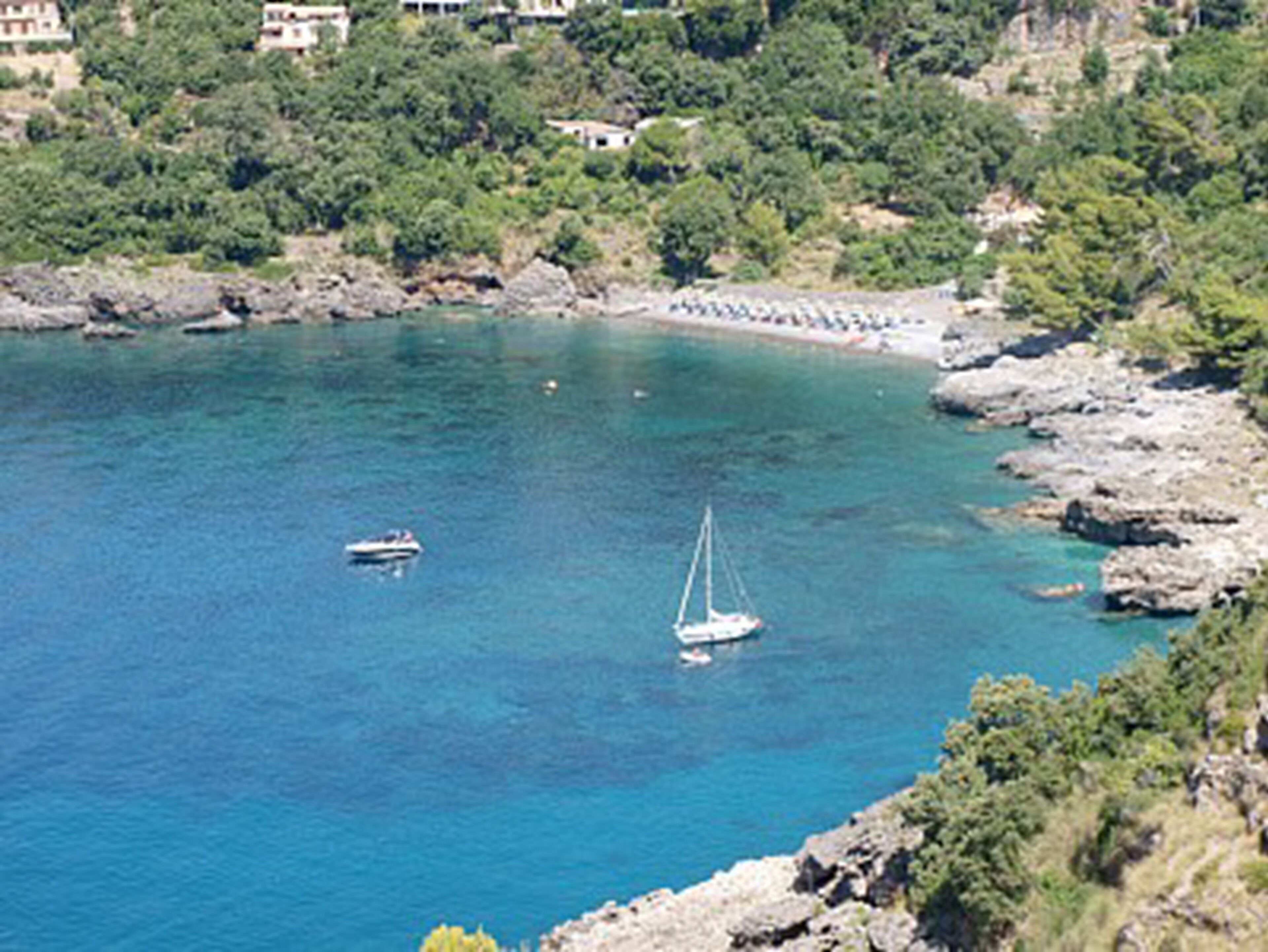 A coastal area with rocky terrain and clear blue water.