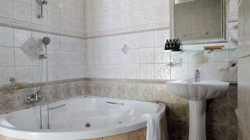 A bathroom with a bathtub, a sink, and a mirror.