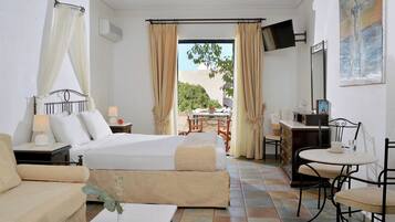 Een hotelkamer met een bed, een bureau, een stoel, een tafeltje en een televisie.