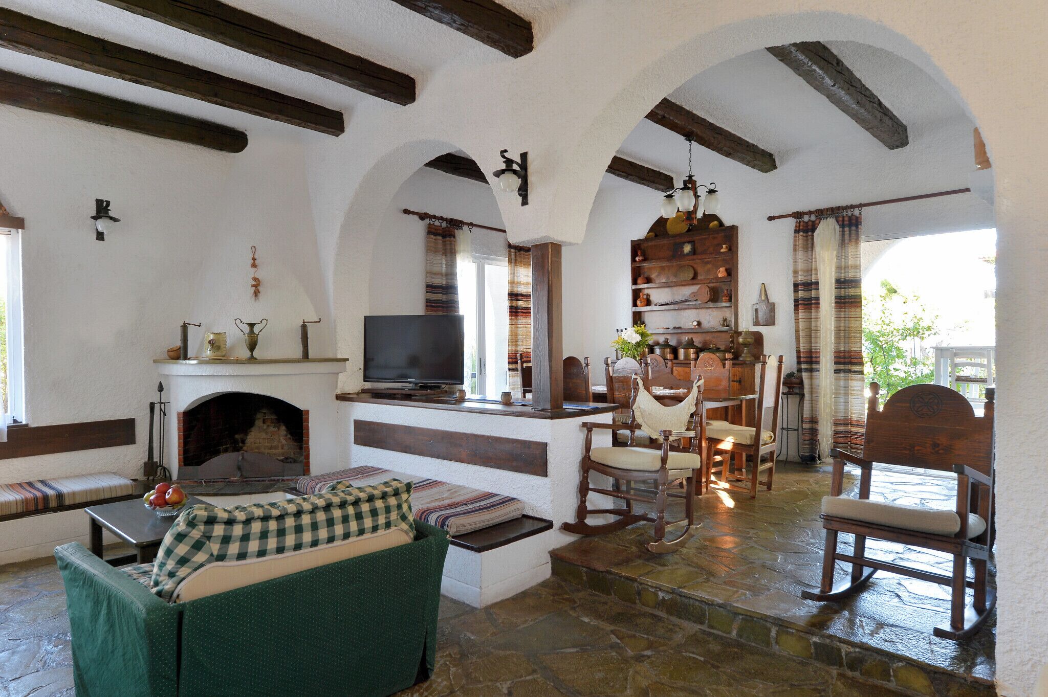 Una sala de estar acogedora con chimenea, zona de estar y televisor.