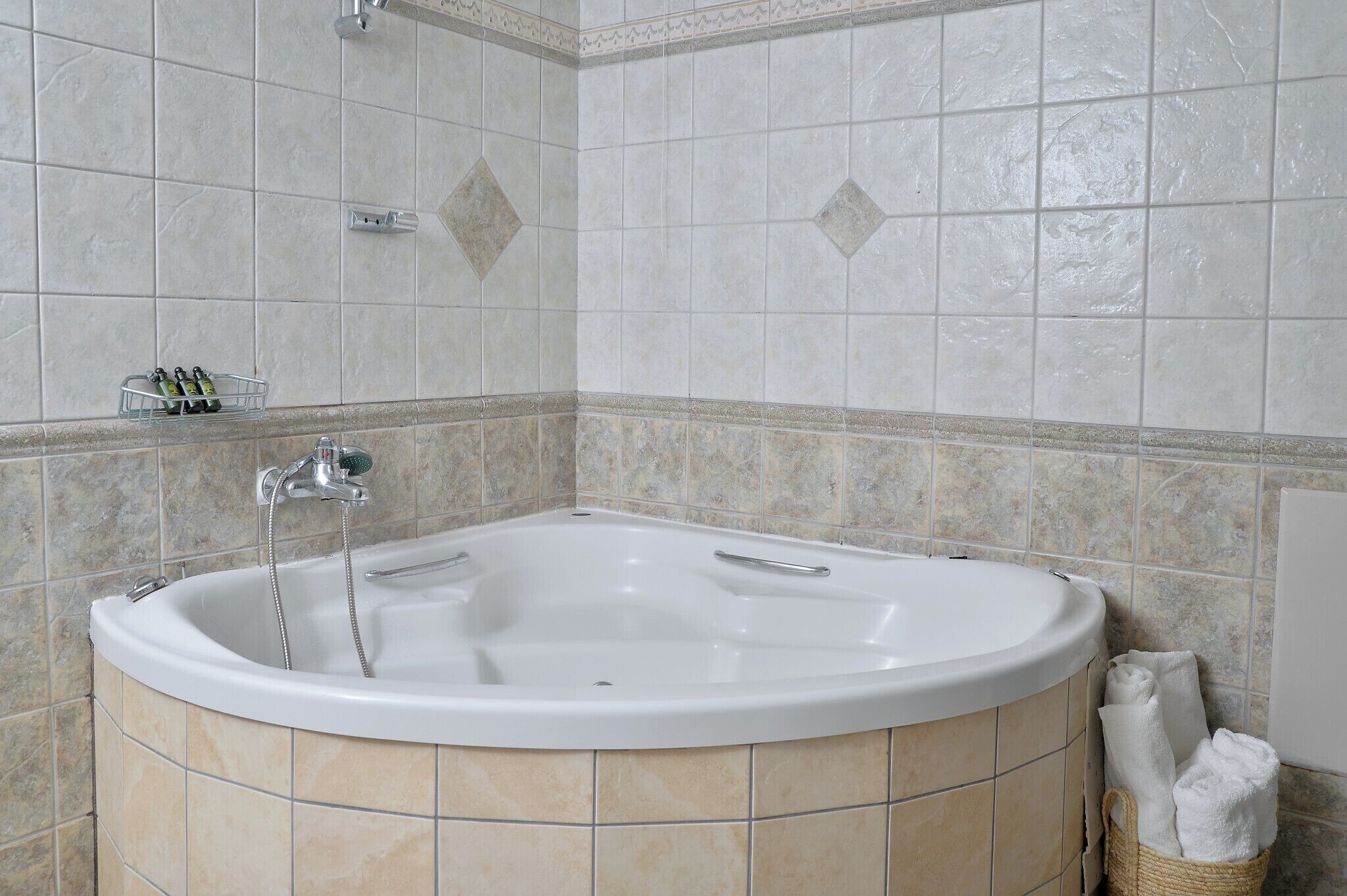 Un baño con una bañera independiente, ducha y perchero para toallas.