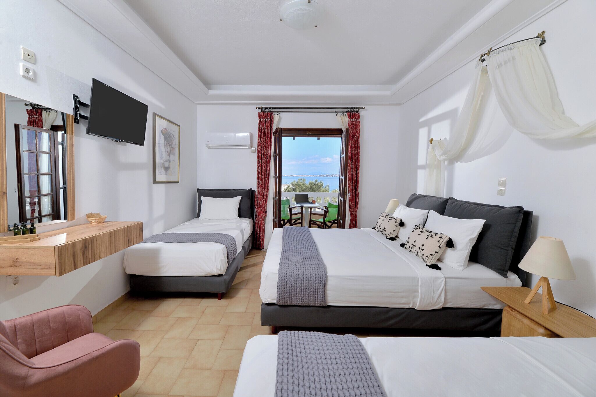 Une chambre d’hôtel avec deux lits, un bureau, une chaise et un téléviseur.