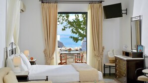 Een hotelkamer met een bed, bureau, stoel, kast en televisie.