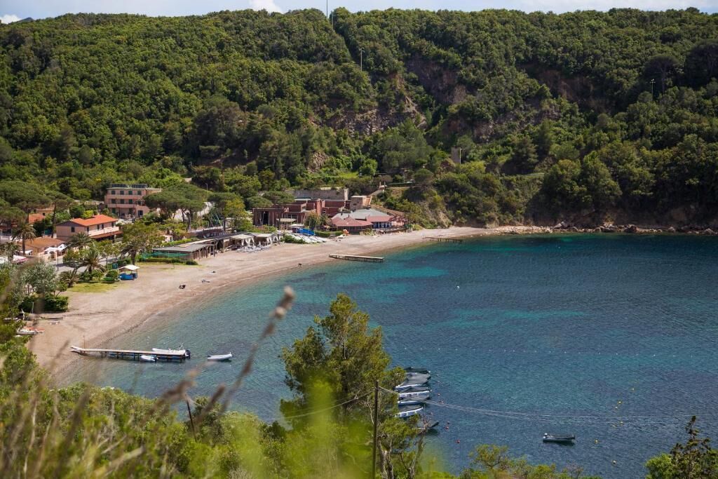 Un pueblo costero con playa, barcos y edificios.