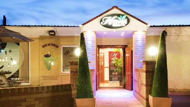 Entrada de um hotel com uma placa que diz "Havelis".