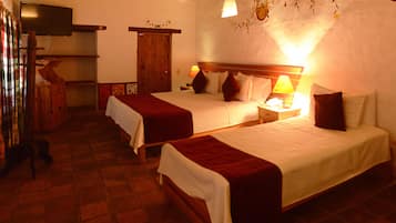 A hotel room with two beds, a television, and a wooden wardrobe.