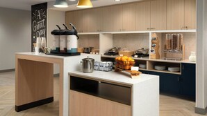 Una cocina moderna con armarios de madera, una isla central e iluminación colgante.