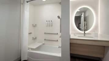 Un baño moderno con cabina de ducha, tocador con espejo y bañera.