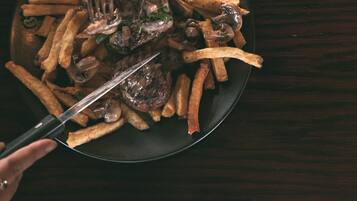 Un plato de comida con papas fritas y champiñones, servido con un tenedor.
