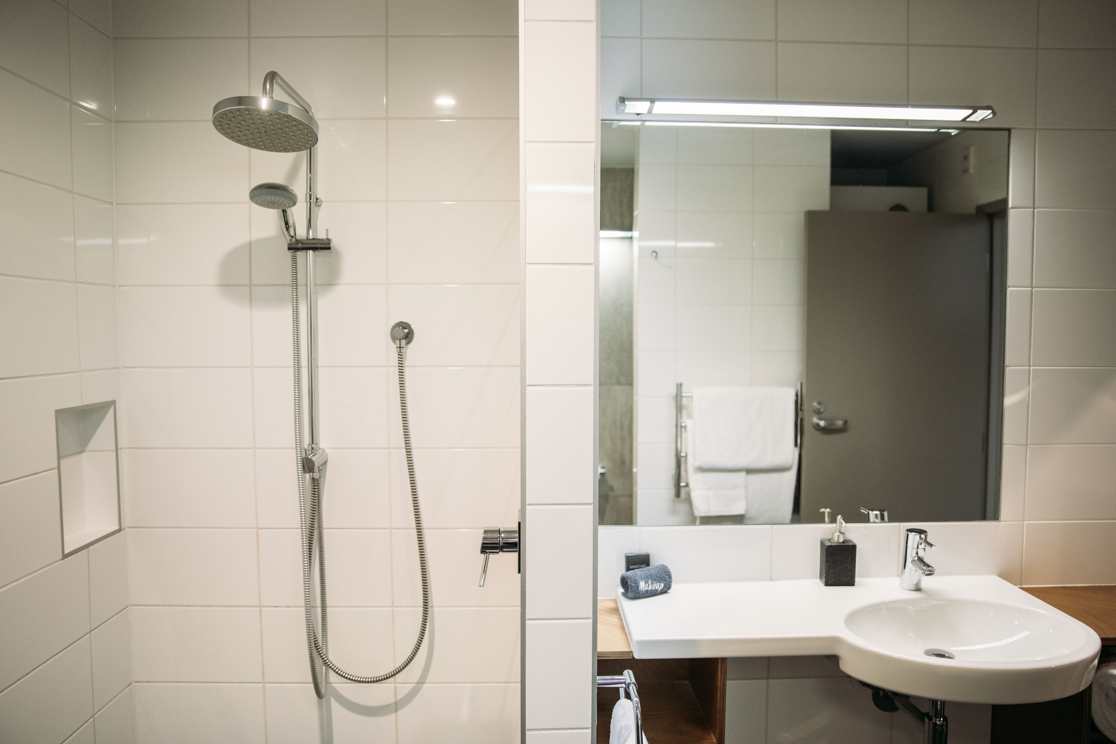 A bathroom with a shower, sink, and mirror.