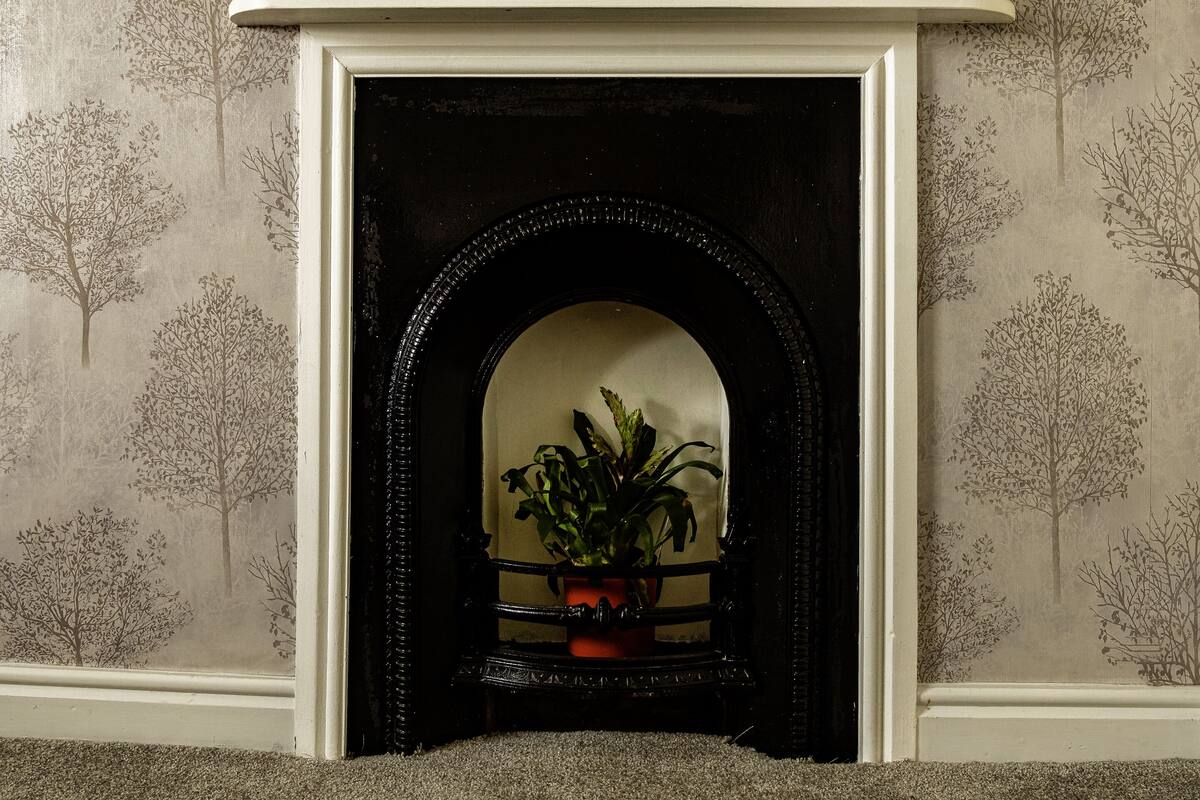 A fireplace with a mantel decorated with two rabbit figurines.