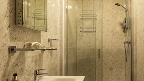 A modern bathroom with a glass-enclosed shower, a white sink, and a marble wall. - The Green Dragon at Bedale by OYO (Bedale)