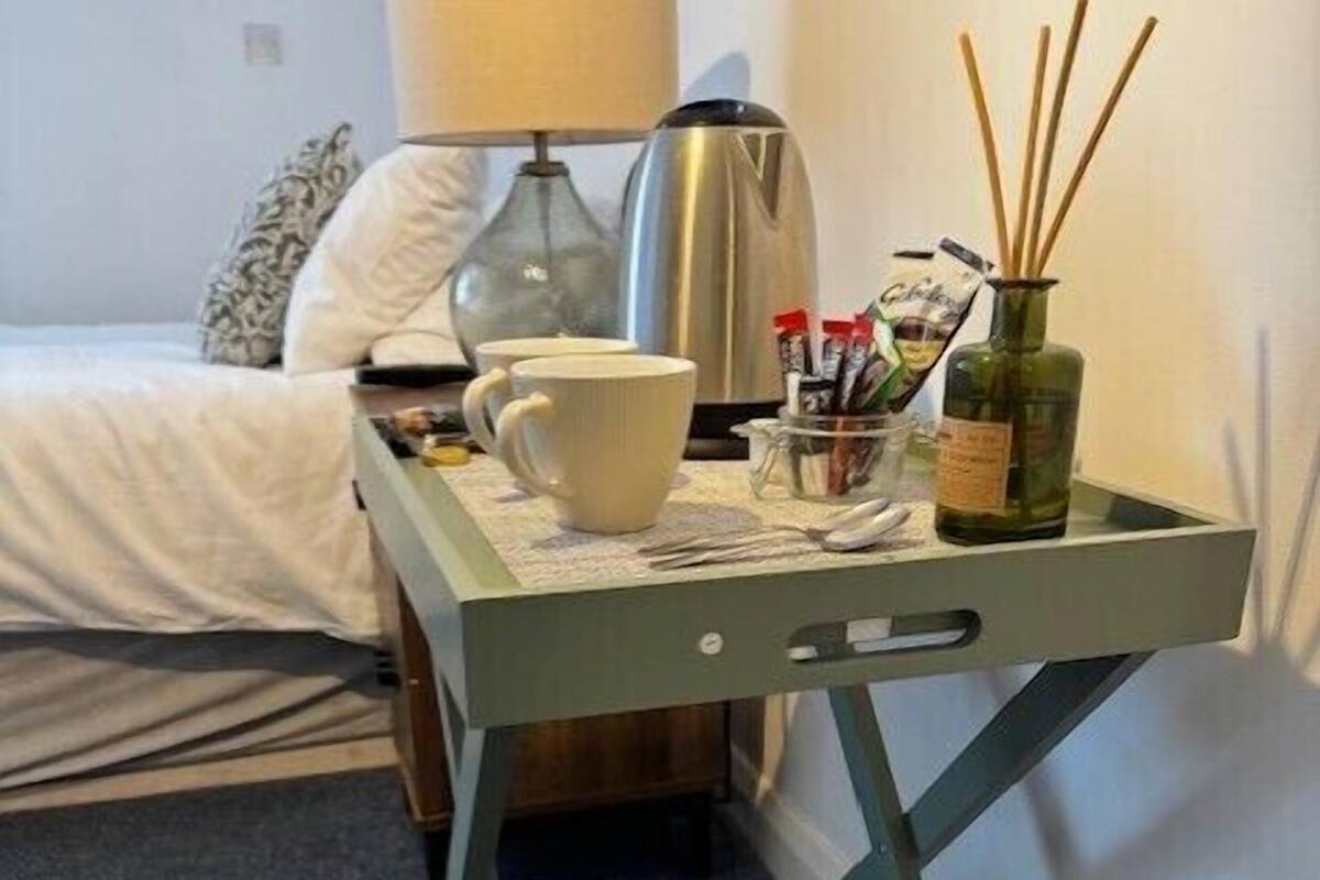 Ein kleiner Tisch mit Tasse, Flasche und einer Aufbewahrungsbox.