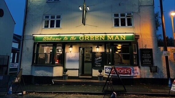 Ein Gebäude mit einem Schild, auf dem „Welcome to the GREEN MAN“ steht.